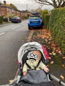Child in buggy faces dangerous road route due to parked car