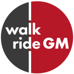 Walk Ride GM's logo which shows the text in white font over the top of a black (left) and red (right) circle