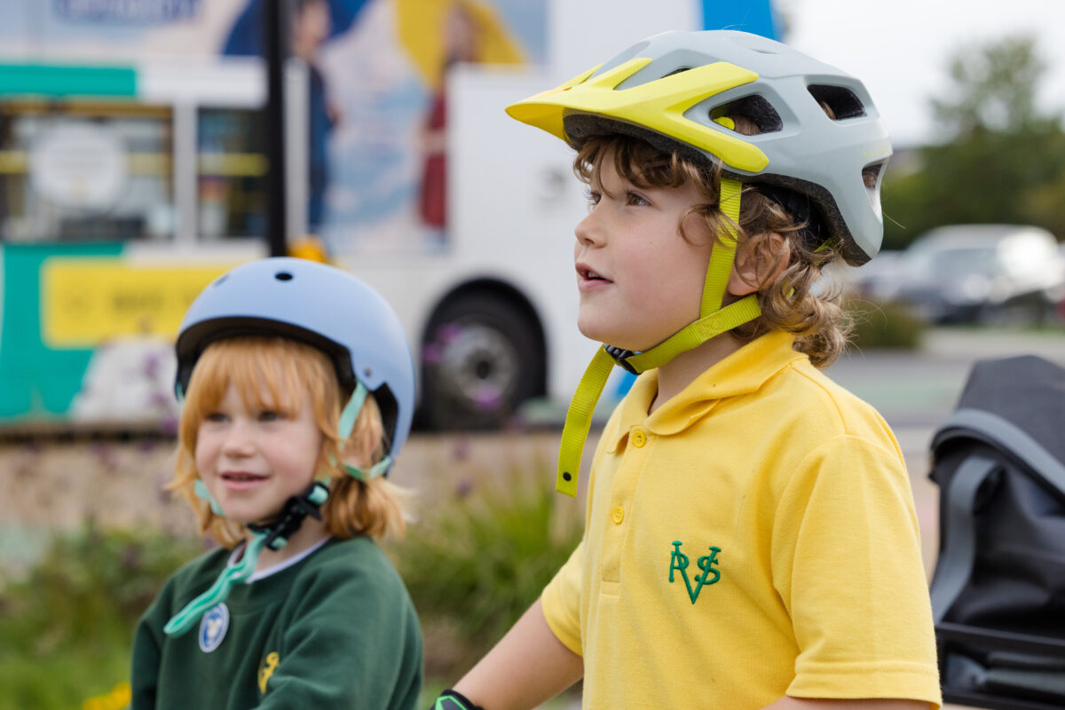 Two school children wearing cycle helmets