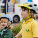 Two school children wearing cycle helmets