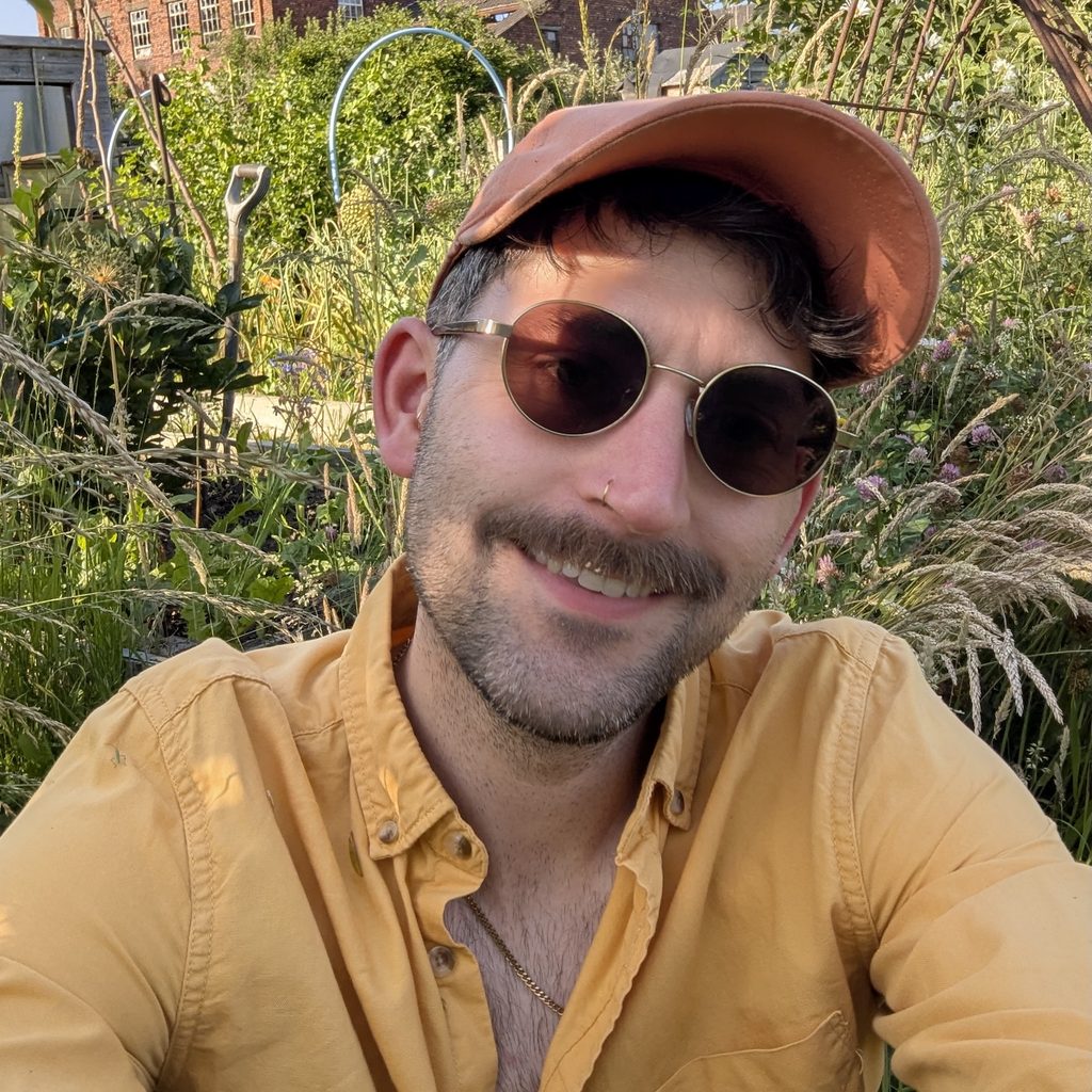 Sam Hayes selfie in a sunny community garden